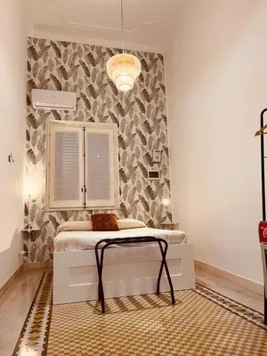 a bedroom with a bed in a room with a wall at Don Bosco Suite in Palermo