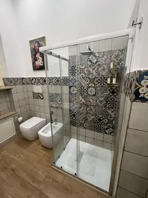 a bathroom with a glass shower with a toilet at Don Bosco Suite in Palermo