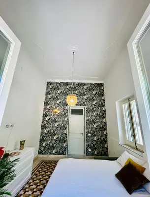 a bedroom with a bed and a wall at Don Bosco Suite in Palermo