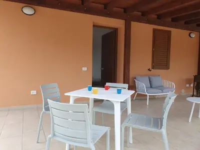 a white table and chairs and a couch at Apartment MareLuna by Interhome in Balestrate