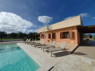 a group of chairs sitting next to a swimming pool at Apartment MareLuna by Interhome in Balestrate