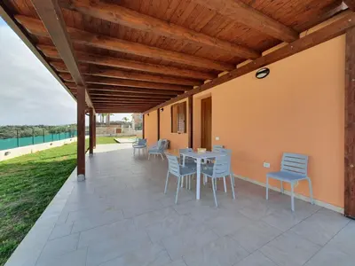 a patio with blue chairs and a table on it at Apartment MareLuce by Interhome in Balestrate