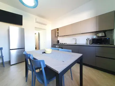 a kitchen with a table and blue chairs in a room at Apartment MareLuce by Interhome in Balestrate