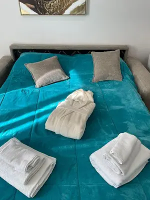 a blue bed with two white towels on it at Da Andrea in Carini