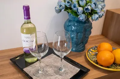 a table with two wine glasses and a bottle of wine at Al Capo Suite Home in Palermo