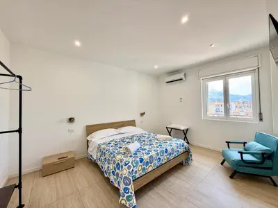 a bedroom with a bed and a blue chair at Il Capriccio in Palermo