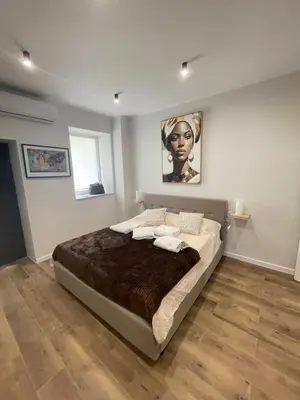 a bedroom with a large bed with a painting on the wall at Gold Rooms in Carini