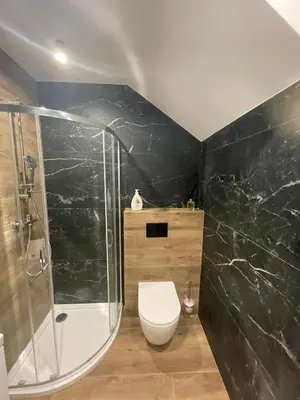 a bathroom with a toilet and a glass shower at Gold Rooms in Carini