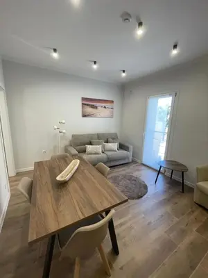 a living room with a wooden table and a couch at Gold Rooms in Carini