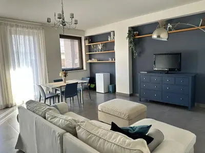 a living room with a couch and a tv and a table at Matteotti 17 Easy in Cinisi