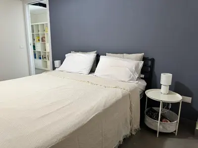 a bedroom with a bed with white sheets and a table at Matteotti 17 Easy in Cinisi