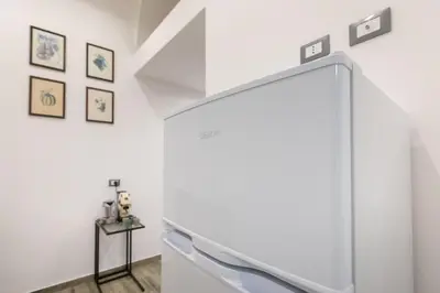 an empty white room with a table and a refrigerator at Aromarìa Palace in Palermo