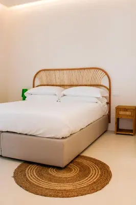 a bedroom with a bed with a rattan headboard at Villa Ippolita - Apartment with Exclusive Garden in San Vito lo Capo