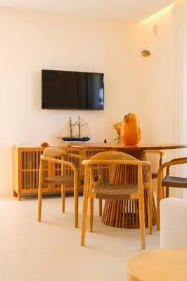 a dining room with a table and a tv at Villa Ippolita - Apartment with Exclusive Garden in San Vito lo Capo