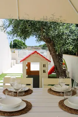 a table with plates and glasses on top of it at Villa Ippolita - Apartment with Exclusive Garden in San Vito lo Capo