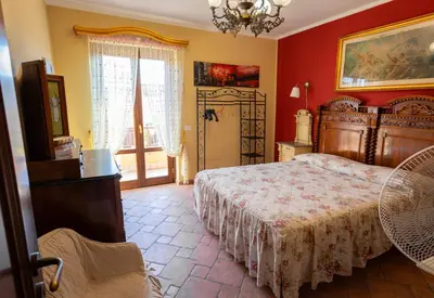 a bedroom with a large bed and red walls at Casa Leandra in Casteldaccia