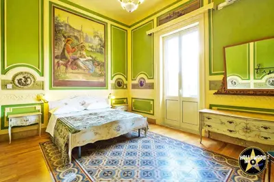 a bedroom with green walls and a bed and a window at Hollywood Inn Palermo in Palermo