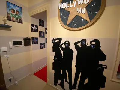 a wall painting of four people with binoculars in a room at Hollywood Inn Palermo in Palermo
