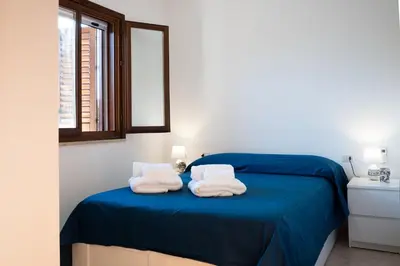 a bedroom with a blue bed with towels on it at Villa Lipari in Castellammare del Golfo