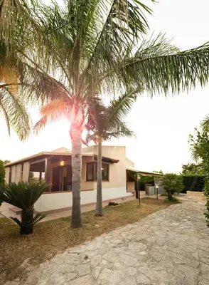 a house with two palm trees in front of it at Villa Lipari in Castellammare del Golfo