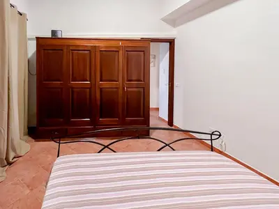 a bedroom with a bed and a wooden cabinet at Kemonia home in Palermo