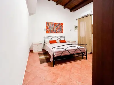 a bedroom with a bed and a painting on the wall at Kemonia home in Palermo