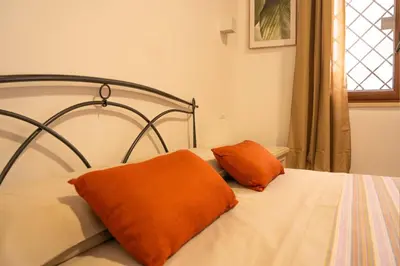 a bed with two orange pillows on top of it at Kemonia home in Palermo