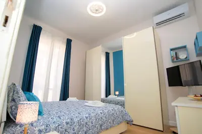 a bedroom with a blue bed and a mirror at Enjoy Palermo in Palermo