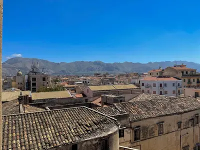 a city with roofs and mountains in the background at Settimo Cielo al Massimo Guest House in Palermo