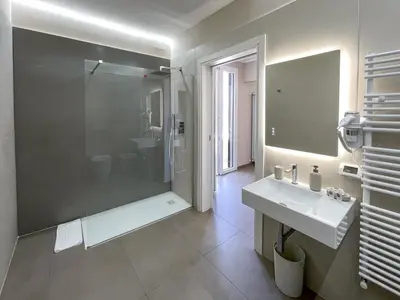 a white bathroom with a shower and a sink at Settimo Cielo al Massimo Guest House in Palermo