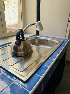 a tea kettle sitting on top of a kitchen sink at That's Amuri in Palermo