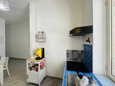 a small room with a table and a kitchen at That's Amuri in Palermo