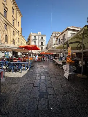 an outdoor market with tables and umbrellas on a street at That's Amuri in Palermo