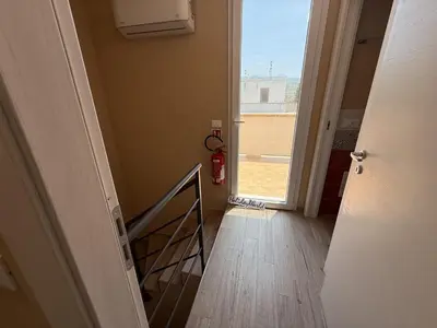 a hallway with a stairway with a fire hydrant and a window at Villetta Sunrise by Holiday World in Lascari