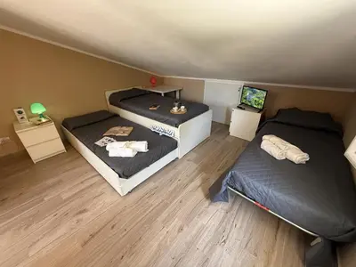a room with two beds and a television in it at Villetta Sunrise by Holiday World in Lascari
