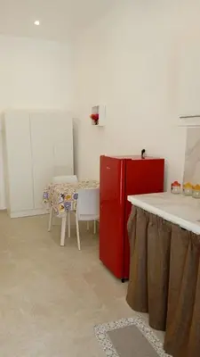 a kitchen with a red refrigerator and a table at Scialari - Palermo Holiday Home in Palermo