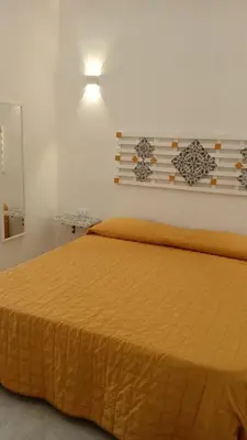 a bedroom with a large bed with a yellow bedspread at Scialari - Palermo Holiday Home in Palermo