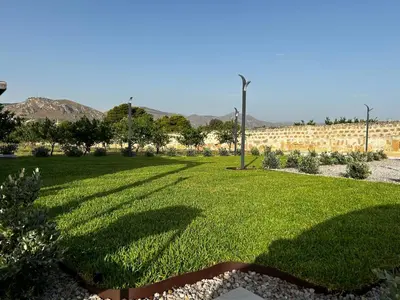 a park with green grass and a wall at Case Vacanze Villa Parisi in Bagheria