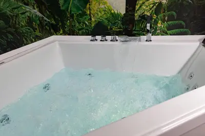 a bath tub filled with water in a bathroom at Lolli Boutique & SPA Al Massimo in Palermo