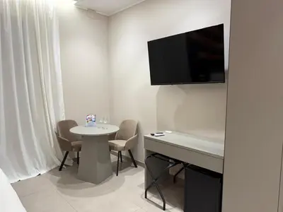 a room with a table and a tv on the wall at Lolli Boutique & SPA Al Massimo in Palermo
