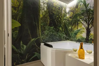 a room with two wine glasses and a mural of a jungle at Lolli Boutique & SPA Al Massimo in Palermo