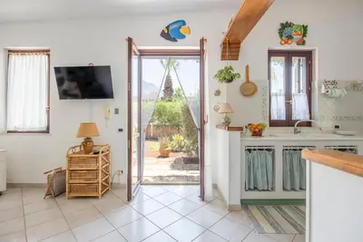a kitchen with a door open to a garden at Acquamarina 24 in San Vito lo Capo