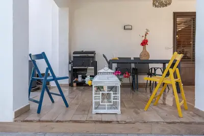 a room with three chairs and a table with a glass lantern at Villa a due passi dal mare 