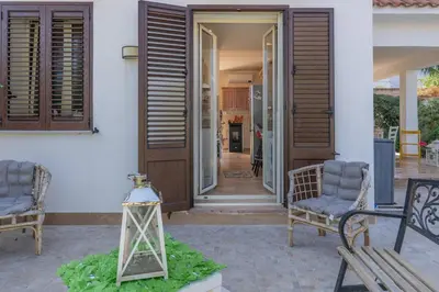 a house entrance with two chairs and a porch at Villa a due passi dal mare 