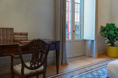 a room with a desk and a chair and a window at Gilded Age Luxury dream apartment historic center in Palermo