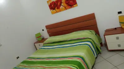 a bedroom with a bed with a colorful blanket on it at Villa Maria in Campofelice di Roccella