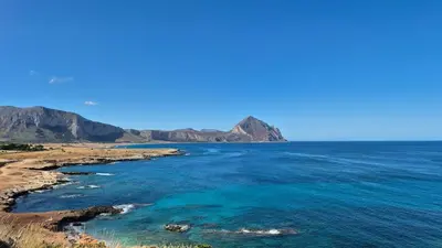 a view of the ocean with mountains in the background at Jecko Apartment in San Vito lo Capo