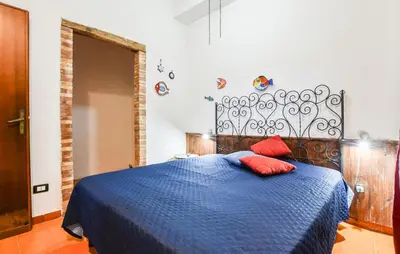 a bedroom with a blue bed with two red pillows at Nice Apartment In Trappeto With Wifi in Trappeto