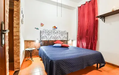 a bedroom with a blue bed with a red curtain at Nice Apartment In Trappeto With Wifi in Trappeto
