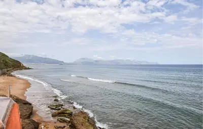a view of a beach with mountains in the distance at Nice Apartment In Trappeto With Wifi in Trappeto